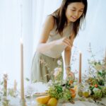 Photo of Yi Huang, founder of Yiventful Co., providing wedding planning services serving couples in Northern California, making last minute table arrangements