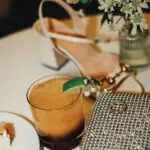 Photo of decor details at dinner (cocktail, purse, shoes, accessories, flowers) , at an elegant wedding planned by Yiventful Co. at MacArthur Place Hotel, Sonoma.
